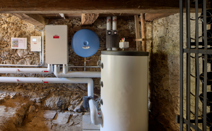 Local technique avec ballon d’eau chaude, vase d’expansion et installation de chauffage moderne dans un bâtiment historique