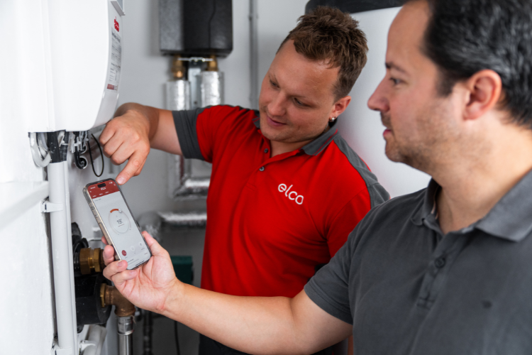 ELCO Servicetechniker erklärt einem Kunden die Bedienung der REMOCON NET App zur digitalen Steuerung und Überwachung der Heizungsanlage.