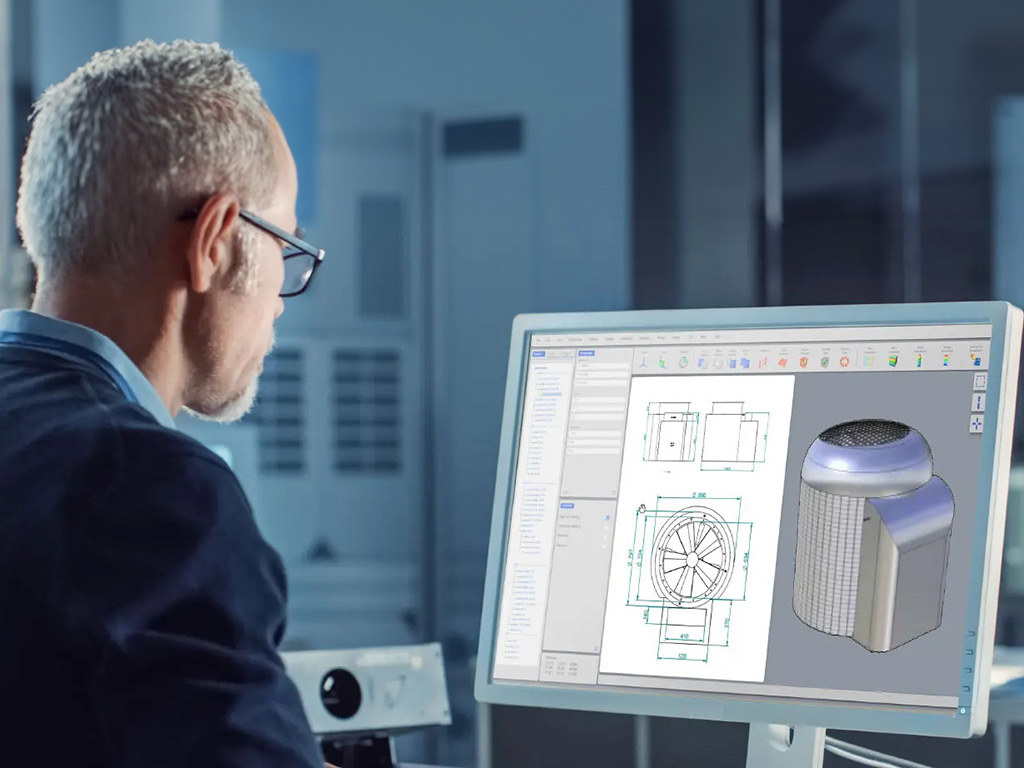 Un uomo lavora al computer e osserva un modello 3D con i disegni tecnici di una termopompa sullo schermo